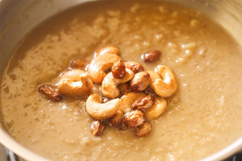 Fried cashews and raisins on the ada pradham in pan.