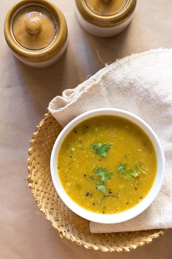 amti garnished with coriander leaves and served in a white bowl.