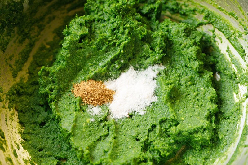 Seasonings and spices added to besan and spinach mixture.